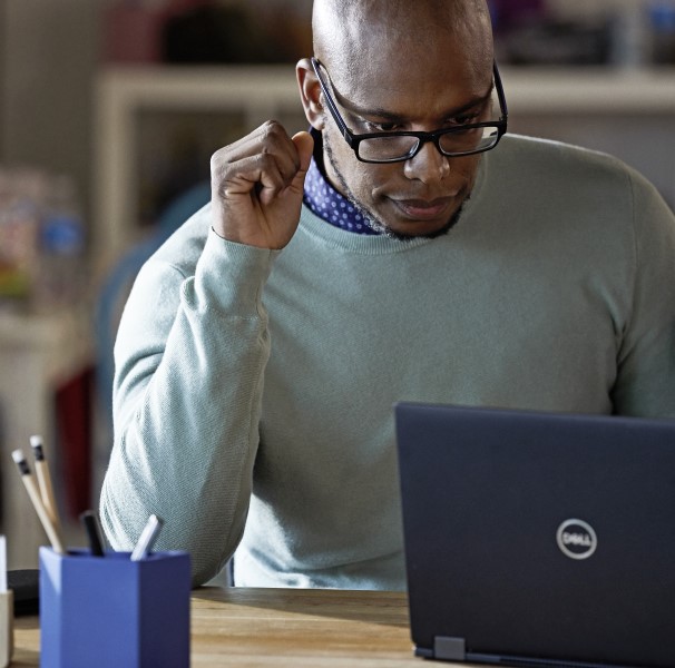 Male working remotely from his home office on a Dell Latitude 13 device, logo/product shot.