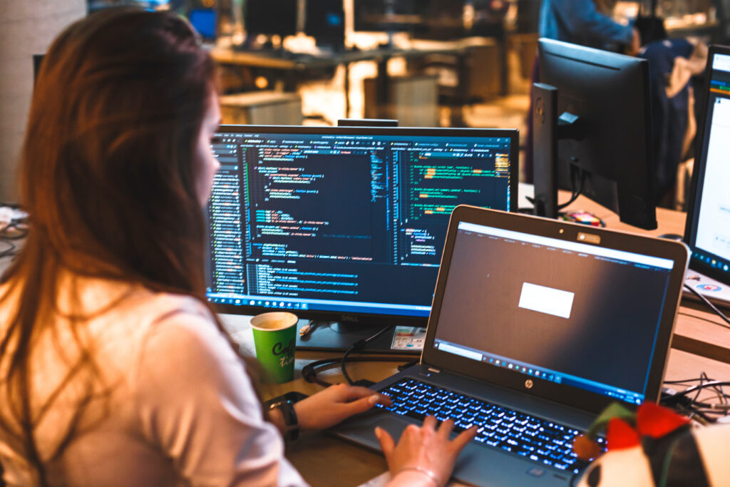 A female programmer works at the computer at her desk