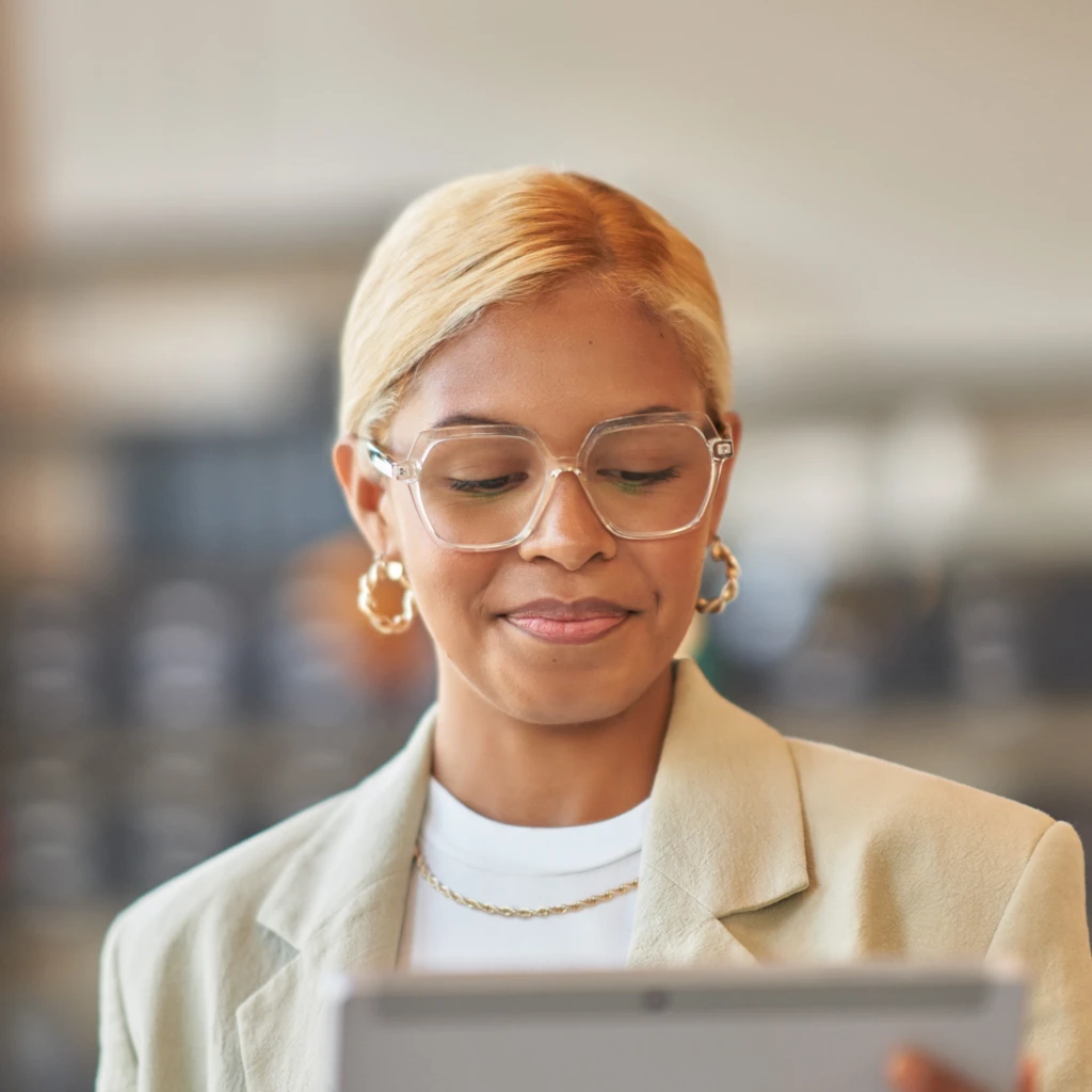 A woman wearing glasses and a tan suit